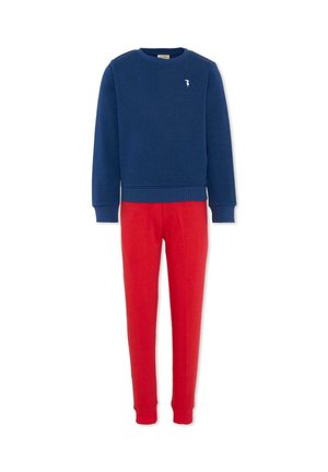 Felpa blu navy a maniche lunghe con piccolo logo bianco abbinata a pantaloni aderenti rossi, progettata per l'uso quotidiano.