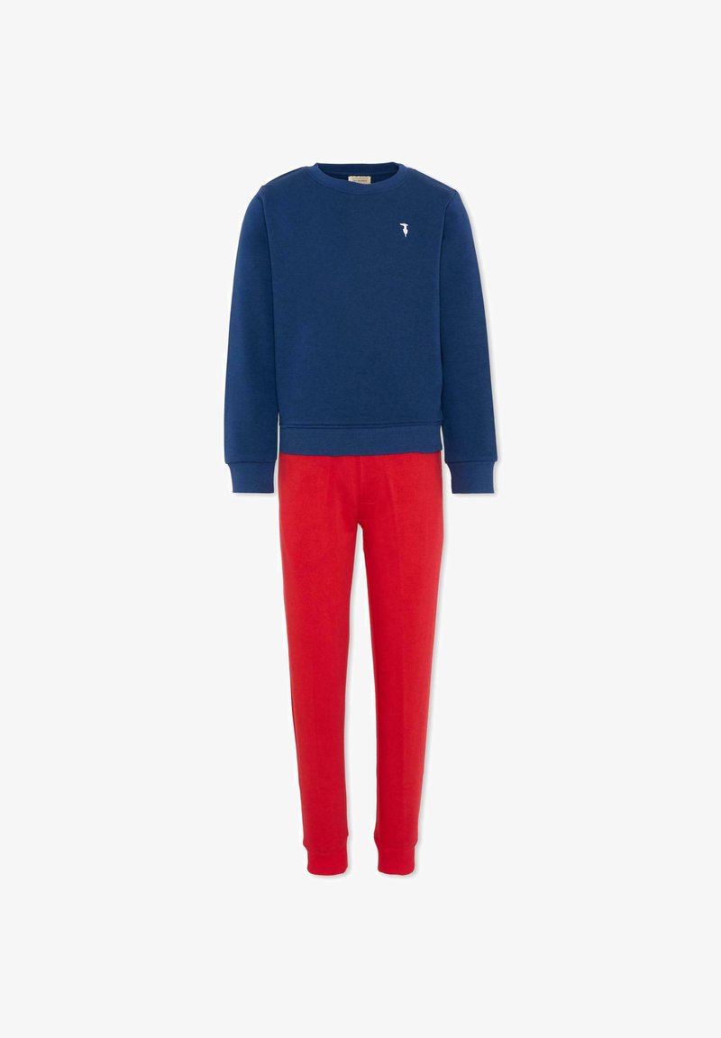 Sweat-shirt bleu marine à manches longues avec petit logo blanc, associé à un pantalon rouge ajusté, conçu pour une tenue décontractée.