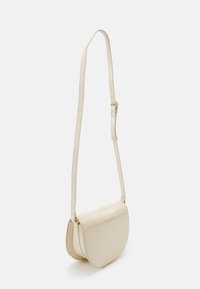 Borsa a tracolla in pelle texturizzata color crema, con forma curvata, hardware dorato e tracolla regolabile. Nota è la lavorazione a quadri all'esterno.