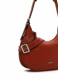 Sac à épaule en cuir rouge avec une forme courbée, finition texturée, bandoulière réglable et quincaillerie en ton argenté. Présente un logo en relief et des détails de couture.