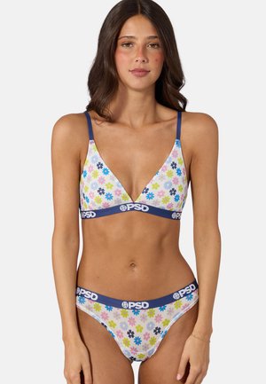 Donna che indossa un set coordinato di reggiseno e mutandine con stampa floreale e bande elastiche blu scuro con l'etichetta "PSD" su uno sfondo semplice.