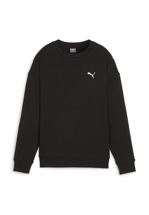 Zbliżenie osoby noszącej czarną bluzę Puma i niebieskie dżinsy, skupiające się na dolnej części pleców i szczegółach ubrania.