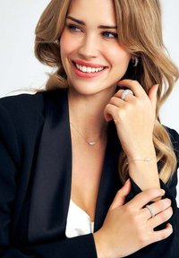 Silver smycken med fina kedjor och detaljer, inklusive ett armband, ett halsband och en ring prydd med gnistrande stenar.