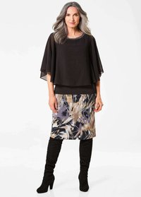 Schwarzes Chiffon-Oberteil mit transparenten Ärmeln, über einem gemusterten grauen Rock mit beigen und lila abstrakten Designs geschichtet. Knielange schwarze Stiefel.