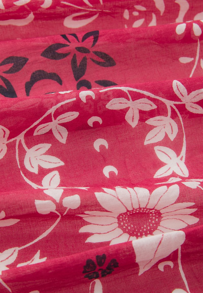Różowa tkanina z kwiatowym wzorem w białe i czarne motywy, z dużymi kwiatami i ułożonymi wzorami liści, gładka tekstura o lekkiej, zwiewnej jakości.
