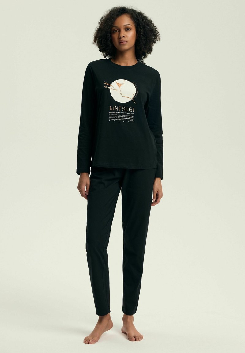 Czarna bluzka z długim rękawem z grafiką Kintsugi, zestawiona z pasującymi czarnymi spodniami, wykonana z miękkiego, lekkiego materiału.