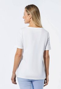 Witte kortekorte mouwen t-shirt met een ronde halslijn en opgerolde mouwen, van de achterkant gepresenteerd, met een gladde textuur en een relaxte pasvorm.