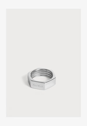 Sekskantet sølv metalring med indvendig gevind og indgraveret tekst på den ene side på hvid baggrund.