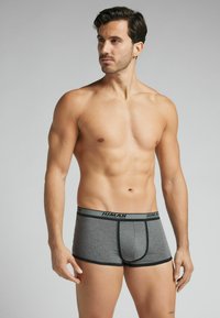 Grijze boxershorts van zachte stof, met een zwarte elastische tailleband met witte tekst en een gevormde voorkant.