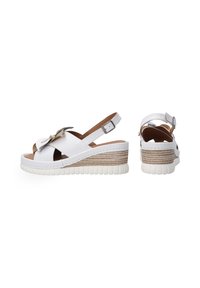 Witte leren wedge sandalen met enkelbandje, featuring kruisslingers, lichtbruine accenten en een geprofileerd plateau in neutrale tinten.