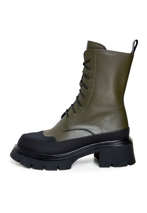 Olivgrüner Schnürstiefel mit glänzendem Finish, Gummikappe, klobigem schwarzen Absatz und strukturiertem Sohlen.