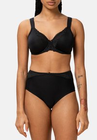 Brassiere in pizzo nero e microfibra con spalline regolabili, caratterizzato da un design a coppa liscia e bordi decorativi in pizzo. Mutandine nere a vita alta con dettagli in pizzo.