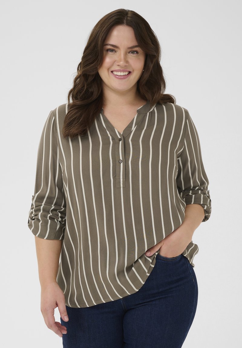 Gray-green blouse with vertical white stripes, v-neckline, and roll-up sleeves. Soft fabric with slight sheen, styled with dark blue jeans.