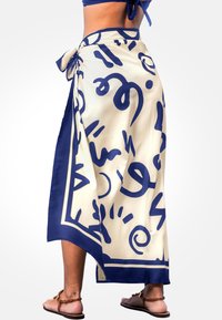 Wickelrock in Creme und Navy mit abstrakten Mustern. Hergestellt aus glattem Stoff, mit gebundenem Bund und einem kontrastierenden Randdesign.