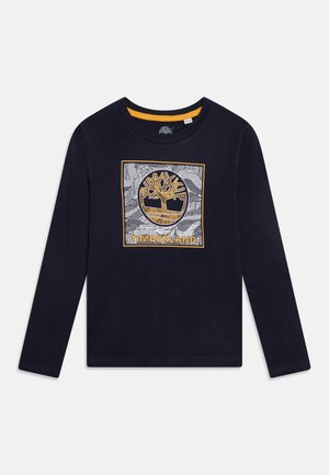 Long-sleeve navy t-shirt with a round neckline featuring a white and gold Timberland logo graphic at the center. Cotton material.