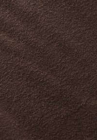 Texture en suède marron avec des fibres douces et légèrement irrégulières visibles à la surface et des motifs de grain naturel.
