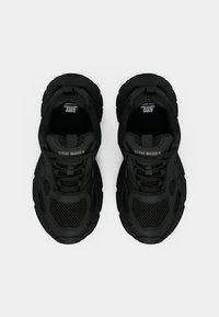 Pair of black Steve Madden chunky sneakers with mesh and leather details, viewed from above on a white background.