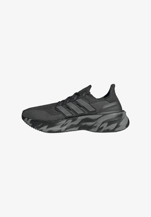 Scarpa da ginnastica nera con tomaia in maglia testurizzata, tre strisce nere sui lati e una suola grigio scuro con motivo.