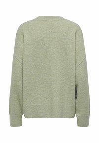 Pull en maille verte à coupe décontractée, col rond et épaules tombantes. Texture douce avec poignets et ourlet côtelés. Pas de motifs ni accessoires visibles.