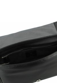 Borsa in pelle nera con una superficie liscia, dotata di chiusura a zip e interno foderato con un delicato motivo a logo. Dettagli in metallo argentato.