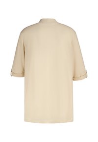 Chemise beige à manches courtes avec une coupe décontractée, dotée d'un empiècement au dos et de détails de poignets roulés, fabriquée dans un tissu lisse et léger.