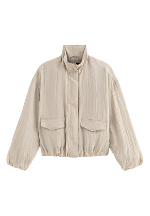 Beige lichtgewicht jack met hoge kraag, ritssluiting aan de voorkant, twee klepzakken en elastische zoom en manchetten.