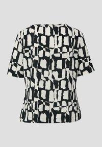Korte mouw top met een zwart-wit abstract patroon, in een relaxte pasvorm en met een soepele stoftextuur. Achteraan zijn de naden en de halslijn zichtbaar.