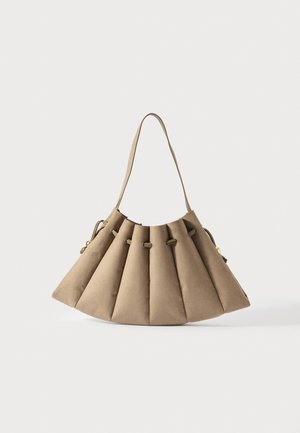 Bolsa de camurça bege com design plissado, detalhe de cordão e uma alça de ombro, sobre um fundo branco.