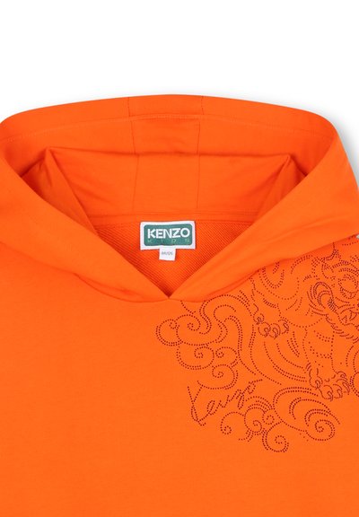 Sweat à capuche orange avec cordon de serrage, présentant un motif texturé et un logo de marque en détails en pointillés à l'avant. Matériel en coton.