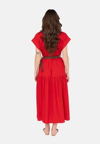 Rotes, knöchellanges Kleid mit kurzen Ärmeln, gerafftem Rock und einem braunen Gürtel in der Taille. Glatte Stofftextur, keine sichtbaren Muster.