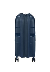 Valigia rigida navy con scanalature orizzontali, doppia cerniera e quattro ruote nere per la mobilità. Forma rettangolare.