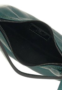 Borsa a tracolla in pelle verde con chiusura a zip, l'interno include una fodera in tessuto nero e un'etichetta. Presenta una tracolla sottile.