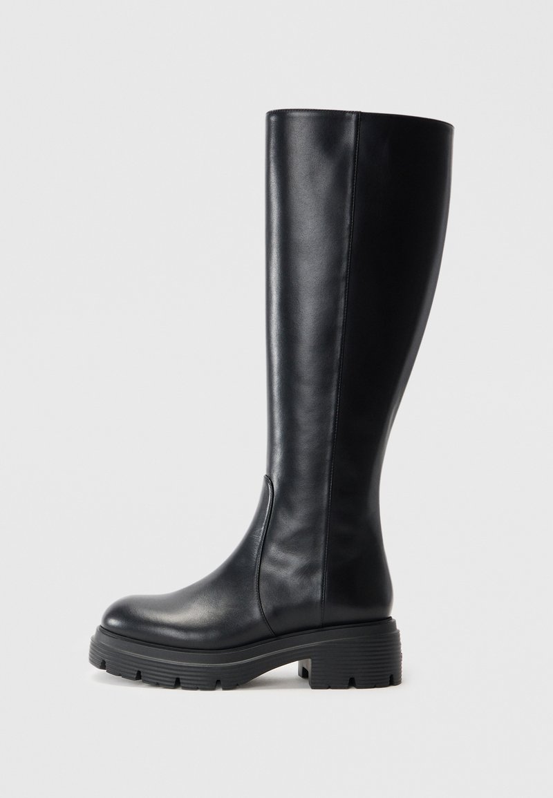 Black knee-high boots made of smooth leather, featuring a rounded toe and a chunky rubber sole with tread patterns for traction.
