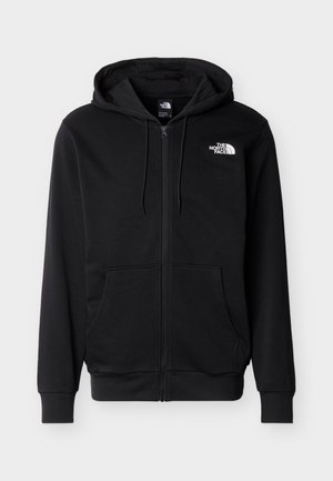 Μαύρη φούτερ ζακέτα με φερμουάρ, εμπρόσθιες τσέπες, κουκούλα με κορδόνι και λευκό λογότυπο The North Face στο αριστερό στήθος, σε απλό φόντο.