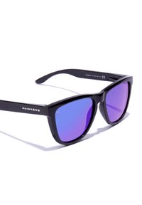 Black plastic sunglasses with a geometric frame and purple gradient lenses. Features "HAWKERS" branding on the temples. Smooth surface texture.