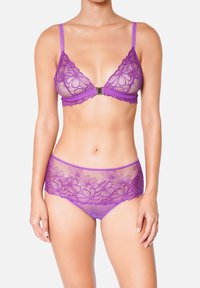 Soutien-gorge en dentelle violette et culotte assortie avec broderie florale, panneaux transparents, bretelles réglables et détail de fermeture à l'avant.