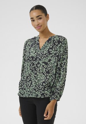 Blouse vert et noir à motif léopard avec un col en V, des manches longues et des poignets froncés, fabriquée en tissu léger.