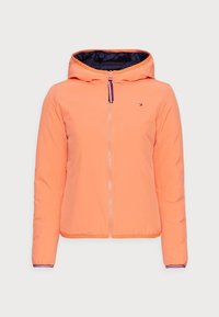 Giacca arancione con cappuccio, chiusura con zip, design imbottito e interno blu navy. Presenta un logo sul petto e dettagli a righe nei polsini.