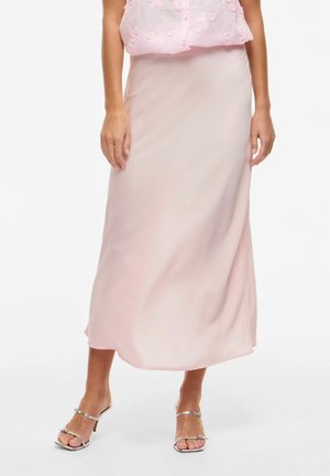 Light pink satin maxi skirt with a smooth texture, fitted waist, and subtle sheen, complemented by metallic silver open-toe heels.