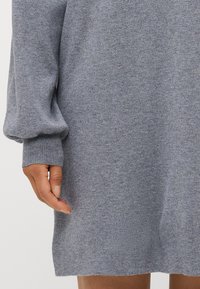 Gray knit sweater dress with a relaxed fit, featuring voluminous long sleeves, ribbed cuffs, and a smooth, soft texture.