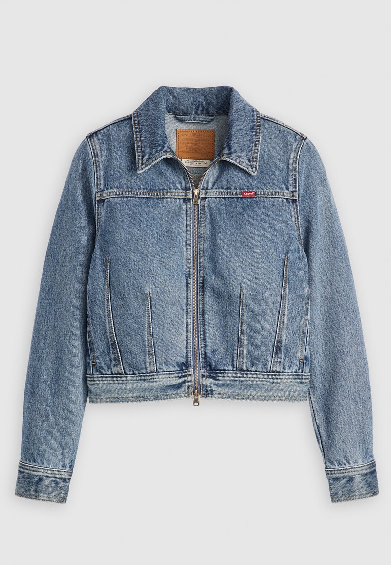 Chaqueta de mezclilla azul claro con cremallera frontal, cuello puntiagudo, dos bolsillos en el pecho y detalles de costura. Presenta un parche de cuero con la marca en la parte posterior.