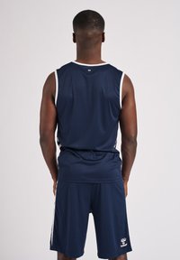 Marinblå sporttröja och shorts av slätt tyg, med vita accenter och en logotyp på vänster ben. Inga mönster eller ytterligare detaljer synliga.