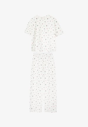 Set di pigiama in cotone bianco composto da una maglia a maniche corte e pantaloni lunghi, entrambi decorati con un piccolo motivo floreale rosso e verde su tutta la superficie.