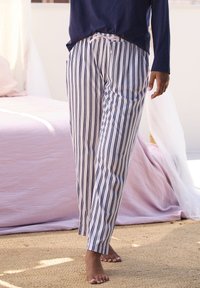 Striped pajama pants in white and navy, featuring a drawstring waist and a relaxed fit, made of lightweight fabric for comfort.