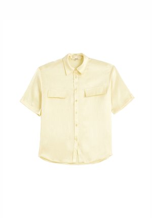 Camisa amarilla de manga corta, con botón, hecha de una tela suave, que presenta dos bolsillos en el pecho y un sutil patrón texturizado.