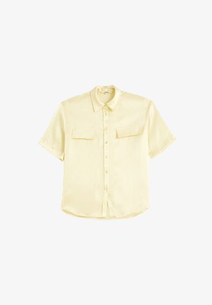 Kortærmet gul skjorte med knapper lavet af blødt stof, der har to brystlommer og et subtilt tekstureret mønster.