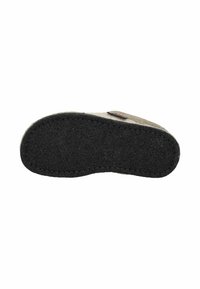 Suela negra de fieltro con parte superior beige, con bordes cosidos y un pequeño detalle de etiqueta en el lado.