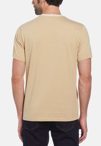 Beige t-shirt met korte mouwen, subtiele strepen, ronde hals en een losse pasvorm. Het materiaal lijkt zacht met een gladde textuur.