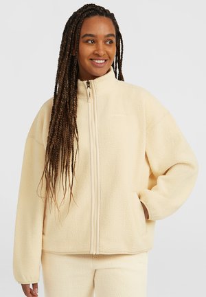 Cream-colored fleece jacket with a high collar, full zipper, and side pockets. Soft texture with a relaxed fit and minimal branding.
