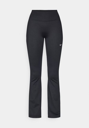 Černé sportovní legíny s vysokým pasem, vyrobené z hladké, elastické tkaniny. Na levém stehně je malý bílý logo Nike.